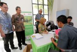 Direktur Produksi PT. Rejoso Manis Indo (PMI) I Gede Wirasute (kanan) didampingi Head Of Busines Banking Bank BNI wilayah Malang Alih Swasono (kedua kiri) menyaksikan langsung pembukaan rekening baru bagi Petani tabu Rakyat di gedung pertemuan PT.RMI di Blitar, Jawa Timur, Selasa (21/5/2019). Pabrik Gula PT.RMI bekerja sama dengen Bank BNI dalam pembiayaan hasil panen petani tebu rakyat yang disetorkan ke pabrik dengan sistem pembayaran 'Cash On Demand' yang memangkas waktu bayar menjadi paling lama 3 hari dengan tujuan agar petani tebu lebih sejahtera dan segera mendapatkan haknya. Antara Jatim/Irfan Anshori/zk.