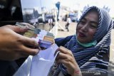 Warga menghitung uang rupiah seusai penukaran uang pecahan kecil di layanan kas keliling di Monumen Juang, Bandung, Jawa Barat, Selasa (21/5/2019). Perwakilan Bank Indonesia Jawa Barat tahun ini menggelontorkan hampir Rp 30 triliun untuk melayani penukaran uang yang sudah disebar ke seluruh daerah di Jawa Barat. ANTARA JABAR/M Agung Rajasa/agr