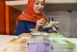 Petugas menghitung uang rupiah pecahan kecil di layanan kas keliling di Monumen Juang, Bandung, Jawa Barat, Selasa (21/5/2019). Perwakilan Bank Indonesia Jawa Barat tahun ini menggelontorkan hampir Rp 30 triliun untuk melayani penukaran uang yang sudah disebar ke seluruh daerah di Jawa Barat. ANTARA JABAR/M Agung Rajasa/agr