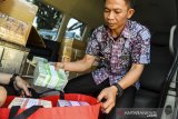 Petugas menghitung uang rupiah di layanan kas keliling di Monumen Juang, Bandung, Jawa Barat, Selasa (21/5/2019). Perwakilan Bank Indonesia Jawa Barat tahun ini menggelontorkan hampir Rp 30 triliun untuk melayani penukaran uang yang sudah disebar ke seluruh daerah di Jawa Barat. ANTARA JABAR/M Agung Rajasa/agr