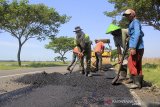 Pekerja menyelesaikan penambalan aspal di jalur alternatif menuju Cirebon dan Jateng di Balongan, Indramayu, Jawa Barat, Selasa (21/5/2019). Perbaikan dan pemeliharaan jalur alternatif tersebut untuk memberikan kenyamanan pengendara saat arus mudik mendatang. ANTARA JABAR/Dedhez Anggara/agr