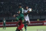 Pesepak bola Persebaya Rachmat Irianto (kiri) mencoba menyundul bola yang dihadang penjaga gawang Kalteng Putra Dimas Galih Pratama (kanan) saat pertandingan Liga 1 2019 di stadion Gelora Bung Tomo, Surabaya, Jawa Timur, Selasa (21/5/2019). Persebaya ditahan imbang Kalteng Putra dengan skor akhir 1-1. Antara Jatim/Moch Asim/zk.