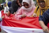 Masyarakat dari Komunitas Indonesia Maju menjahit bendera Merah Putih pada acara peringatan refleksi 111 Tahun Kebangkitan Nasional di Gedung Indonesia Mengugat, Bandung, Jawa Barat, Senin (20/5/2019). Peringatan yang bertajuk Menjadi Indonesia (di) Nusantara tersebut merupakan bentuk memaknai hari kebangkitan nasional sebagai rasa syukur kebhinekaan sehingga terus menjalin persatuan dan persaudaraan sebagai bangsa Indonesia. ANTARA JABAR/Novrian Arbi/agr