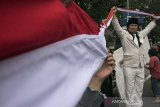 Masyarakat dari Komunitas Indonesia Maju mengangkat bendera merahputih yang telah disambung pada acara peringatan refleksi 111 Tahun Kebangkitan Nasional di Gedung Indonesia Mengugat, Bandung, Jawa Barat, Senin (20/5/2019). Peringatan yang bertajuk Menjadi Indonesia (di) Nusantara tersebut merupakan bentuk memaknai hari kebangkitan nasional sebagai rasa syukur kebhinekaan sehingga terus menjalin persatuan dan persaudaraan sebagai bangsa Indonesia. ANTARA JABAR/Novrian Arbi/agr