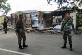 Tiga anggota TNI AD berdiri di depan pos polisi yang telah dibakar massa di Tanjung Raya, Pontianak, Kalimantan Barat, Rabu (22/5/2019). Dua pos polisi di simpang Jalan Tanjungpura dan Tanjung Raya Pontianak dibakar sekelompok warga yang tidak puas dengan hasil Pilpres 2019. ANTARA FOTO/Jessica Helena Wuysang/nym.