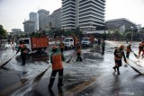 Petugas Penanganan Prasarana dan Sarana Umum (PPSU) membersihkan jalan pascakerusuhan di kawasan Kantor Bawaslu, Jakarta, Kamis (23/5/2019). ANTARA FOTO