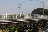 Warga melintas di atas Jembatan Lama Kediri (Brug Over Den Brantas Te Kediri) untuk menyeberangi sungai Brantas di Kota Kediri, Jawa Timur, Jumat (24/5/2019). Jembatan peninggalan kolonial Belanda berkonstruksi besi pertama di Jawa yang telah ditetapkan sebagai bangunan cagar budaya tersebut pada musim mudik lebaran akan dibuka satu jalur sebagai pengurai kemacetan. Antara Jatim/Prasetia Fauzani/zk.