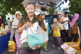 Warga membawa bahan kebutuhan yang dibeli saat digelar pasar murah dalam rangka menyongsong hari raya Idul Fitri di Kabupaten Madiun, Jawa Timur, Rabu (22/5/2019). Pemkab Madiun menggelar pasar murah tersebut guna meringankan beban warga dalam memenuhi kebutuhan bahan pokok saat merayakan Idul Fitri dengan harga bersubsidi, misalnya harga beras di pasar Rp9.500 dijual dengan harga Rp6.500 per kilogram, gula pasir Rp12.500 dijual Rp9.000 per kilogram, minyak goreng Rp13.000 dijual Rp9.000 per liter, mie instant Rp100.000 dijual Rp80.000 per kardus. Antara Jatim/Siswowidodo/zk.