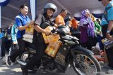 Pegawai Negeri Sipil (PNS) membawa barang yang dibeli saat digelar Pasar Murah Bagi PNS di depan Pendapa Ronggo Jumeno, Kabupaten Madiun, Jawa Timur, Jumat (24/5/2019). Pemkab Madiun menggelar pasar murah bagi PNS diprioritaskan Golongan I dan II guna meringankan beban dalam memenuhi kebutuhan saat merayakan Idul Fitri dengan harga bersubsidi, misalnya harga beras di pasar Rp9.500 dijual dengan harga Rp6.500 per kilogram, gula pasir Rp12.500 dijual Rp9.000 per kilogram, minyak goreng Rp13.000 dijual Rp9.000 per liter, mie instant Rp100.000 dijual Rp80.000 per kardus. Antara Jatim/Siswowidodo/zk.