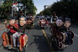 Warga menaiki becak sambil menggunakan penutup wajah bergambar pasangan capres cawapres peserta Pemilu 2019, Joko Widodo- Ma'ruf Amin dan Prabowo Subianto -Sandiaga Uno saat aksi damai di Solo, Jawa Tengah, Jumat (24/5/2019). Dalam aksi tersebut mereka berharap capres nomor urut 01 Joko Widodo dan capres nomor urut 02 Prabowo Subianto segera bertemu guna rekonsiliasi pascapilpres 2019. ANTARA FOTO