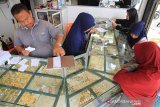 Pedagang menata perhiasan emas di pusat penjualan emas Kota Meulaboh, Aceh Barat, Sabtu (25/5/2019). Menurut pedagang setempat, transaksi penjualan dan pembelian emas sejak sepekan terakhir mulai meningkat untuk memenuhi kebutuhan Lebaran. (Antara Aceh/ Syifa Yulinnas)