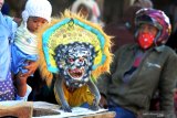 Warga menyaksikan monyet ekor panjang (Macaca Fascicularis) beraksi saat pertunjukan topeng monyet di Pasar Kolpajung, Pamekasan, Jawa Timur, Sabtu (25/5/2019). Pemerintah terus berupaya melakukan gerakan Indonesia Bebas Topeng Monyet 2020 sebagai upaya membebaskan monyet dari jerat profesi topeng monyet melalui kampanye 'animal welfare'. Antara Jatim/Saiful Bahri/zk.