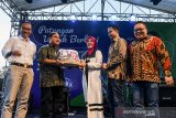 Head of Area West & East Java Grab Indonesia Yose Arizal (kedua kiri) memberikan bingkisan untuk anak yatim secara simbolis kepada Ketua Dewan Kerajinan Nasional Provinsi Jabar Atalia Prartya Kamil (tengah) didampingi Vice President of Regional Growth Expansion Tokopedia Indra Yonathan (kedua kanan), Director OVO Johnny Widodo (kanan) dan Asisten Pemerintahan, Hukum dan Kesejahteraan Sosial Daud Achmad (kiri) saat Festival Patungan Untuk Berbagi di Bandung, Jawa Barat, Minggu (26/5/2019). Kegiatan festival tersebut merupakan gerakan sosial berbasis digital terbesar di Indonesia dan kampanye ini mengajak masyarakat untuk berdonasi lewat platform OVO, Grab dan Tokopedia selama bulan Ramadan guna mendukung keberlangsungan pendidikan anak yatim piatu di Tanah Air. ANTARA JABAR/M Agung Rajasa/agr