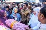 Menteri Pertanian, Andi Amran Sulaiman (ketiga kanani) menyaksikan Gubernur Jatim Khofifah Indar Parawansa (kedua kanan) melayani warga membeli bawang putih saat operasi pasar murah bawang putih di pasar baru porong, Sidoarjo, Jawa Timur, Rabu (22/5/2019). Operasi pasar yang digelar Kementerian Pertanian bersama Kementerian Perdagangan serta Pemerintah Provinsi Jawa Timur dan Bulog tersebut bertujuan untuk menstabilkan harga bahan pokok, terutama harga bawang putih. Antara Jatim/Umarul Faruq/zk.