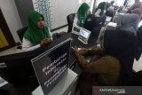 Petugas Badan Penyelenggara Jaminan Sosial (BPJS) melayani pemindahan data peserta Jaminan Kesehatan Nasional “Kartu Indonesia Sehat” (JKN-KIS) di kantor BPJS Kesehatan Lhokseumawe, Aceh, Senin (27/5/2019). Selain meluncurkan Aplikasi Mudik BPJS Kesehatan 2019 yang dapat didownload secara gratis di Google Play Store untuk perangkat Android, BPJS Kesehatan memprioritaskan pelayanan kesehatan peserta menjelang masa libur lebaran tahun 2019 mulai H-7 sampai H+7 Lebaran 2019 (29 Mei - 13 Juni) dan menerima pengobatan di setiap Unit Gawat Darurat (UGD) setiap rumah sakit mitra BPJS tanpa mempersyaratkan surat rujukan. (Antara Aceh/Rahmad)