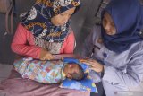 Petugas mendampingi tahanan wanita kasus narkoba, Nur Laila (35) yang memangku bayi mungil yang barusan dilahirkannya di blok wanita Lembaga Pemasyarakatan Klas IIB Tulungagung, Tulungagung, Jawa Timur, Senin (27/5/2019). Saat ditangkap polisi karena narkoba pada Senin (17/5) dan kemudian dibantarkan ke LP Klas IIB Tulungagung pada Rabu (19/5), Nur Laila sudah dalam kondisi hamil 9 bulan. Ia melahirkan keesokan harinya (Kamis, 20/5) dengan bantuan dokter kandungan di RSUD dr Iskak dan di bawah pengawasan petugas LP dan polisi, hingga akhirnya dikembalikan ke LP untuk melanjutkan masa penahanan dengan tetap membawa serta bayinya. Nur Laila berkeras ingin tetap merawat dan menyusui bayinya itu meski berada di balik jeruji besi karena kasus narkoba yang menjeratnya. Antara Jatim/Destyan Sujarwoko/zk.