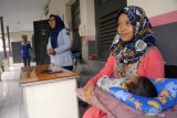 Tahanan kasus narkoba, Nur Laila (35, kanan) menggendong bayi yang barusan dilahirkannya dengan didampingi petugas sipir di blok wanita Lembaga Pemasyarakatan Klas IIB Tulungagung, Tulungagung, Jawa Timur, Senin (27/5/2019). Saat ditangkap polisi karena narkoba pada Senin (17/5) dan kemudian dibantarkan ke LP Klas IIB Tulungagung pada Rabu (19/5), Nur Laila sudah dalam kondisi hamil 9 bulan. Ia melahirkan keesokan harinya (Kamis, 20/5) dengan bantuan dokter kandungan di RSUD dr Iskak dan di bawah pengawasan petugas LP dan polisi, hingga akhirnya dikembalikan ke LP untuk melanjutkan masa penahanan dengan tetap membawa serta bayinya. Nur Laila berkeras ingin tetap merawat dan menyusui bayinya itu meski berada di balik jeruji besi karena kasus narkoba yang menjeratnya. Antara Jatim/Destyan Sujarwoko/zk.