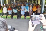 Komandan Lanud Iswahjudi Marsekal Pertama TNI Widyargo Ikoputra (depan keempat kiri) didampingi isteri yang sekaligus Ketua PIA Ardhya Garini Cabang 2/D.II Lanud Iswahjudi Yanti Ikoputra (depan kelima kiri) berfoto bersama dengan sejumlah tenaga kebersihan jalan protokol kawasan Lanud Iswahjudi saat penyerahan bingkisan Hari Raya Idul Fitri di Mako Lanud Iswahjudi Magetan, Jawa Timur, Senin (27/5/2019). Pemberian bingkisan kepada 22 orang tenaga kebersihan jalan protokol tersebut sebagai ungkapan rasa syukur dan penghargaan kepada tenaga kebersihan yang setiap saat menjaga kebersihan jalan kawasan Lanud tetap bersih. Antara Jatim/Siswowidodo/zk.