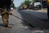 Pekerja melakukan perbaikan jalan Provinsi di Jombang, Jawa Timur, Senin (27/5/2019). Perbaikan jalan raya Provinsi Jombang-Kediri tersebut untuk memperlancar arus mudik dan balik Lebaran. Antara Jatim/Syaiful Arif/zk.