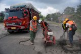 Pekerja memperbaiki Jalan Lintas Sumatera (Jalinsum) di Pemayung, Batanghari, Jambi, Senin (20/5/2019). Perbaikan Jalinsum lintas barat tersebut dilakukan untuk mendukung kelancaran dan keamanan pemudik pada arus mudik Lebaran 2019. ANTARA FOTO/Wahdi Septiawan/aww.