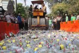 PEMUSNAHAN MINUMAN KERAS. Polisi dan sejumlah elemen masyarakat memusnahkan minuman keras dengan alat berat hasil Operasi Pekat Semeru 2019 di Polresta Kediri, Jawa Timur, Selasa (28/5/2019). Pemusnahan barang bukti sebanyak 10.000 butir pil koplo dan 5.600 botol minuman keras itu merupakan hasil operasi selama tiga belas hari guna menjaga suasana kondusif saat bulan ramadhan. Antara Jatim/Prasetia Fauzani/ZK