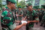 Komandan Kodim 0103 Aceh Utara Letkol Inf Agung Sukoco (kiri) menyerahkan simbolis surat ijin cuti mudik Lebaran 2019 kepada prajurit TNI AD di Makodim 0103 Aceh Utara, Aceh, Rabu (29/5/2019). Pada perayaan Hari Raya Idul Fitri 1440 H masing masing prajurit TNI AD jajaran Kodam Iskandar Muda Aceh dibagi dalam dua gelombang mendapatkan cuti lebaran selama tujuh hari terhitung gelombang pertama 30 Mei -6 juni 2019 dan gelombang kedua 8-15 Juni 2019. (Antara Aceh/Rahmad)