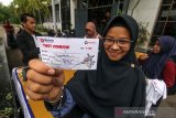 Pemudik menunjukkan tiket mudik BUMN Hadir Untuk Negeri menjelang pemberangkatan program mudik gratis PT Pelindo I (persero) cabang Lhokseumawe di komplek Pelabuhan Krueng Geukuh, Aceh Utara, Aceh, Kamis (30/5/2019). Pemberangkatan 300 pemudik asal Aceh tujuan sejumlah daerah Sumatera Utara Medan dan Pulau Jawa menggunakan angkutan darat itu merupakan sinergi 104 BUMN Mudik Bareng 2019. (Antara Aceh/Rahmad)