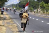 Doni (48) berjalan kaki melintasi jalur Pantura Arjawinangun, Cirebon, Jawa Barat, Sabtu (1/6/2019). Doni berjalan kaki untuk mudik dari Bogor menuju kampung halamannya di Solo dengan menempuh jarak 595 km. ANTARA JABAR/Dedhez Anggara/agr