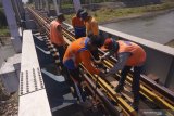 Pekerja melakukan perbaikan rel kereta api di jalur KA Tulungagung-Kediri di atas jembatan 593 nomor 162+4/5, Ngantru, Tulungagung, Jawa Timur, Sabtu (1/6/2019). Perbaikan dilakukan setelah petugas pemeriksa jalur menemukan sejumlah baut rel pada bantalan kayu yang kendor sehingga harus ditata ulang atau dinormalisasi demi meningkatkan keselamatan selama arus mudik Lebaran 1440 H tanpa gangguan. Antara Jatim/Destyan Sujarwoko/zk.