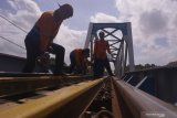 Pekerja melakukan perbaikan rel kereta api di jalur KA Tulungagung-Kediri di atas jembatan 593 nomor 162+4/5, Ngantru, Tulungagung, Jawa Timur, Sabtu (1/6/2019). Perbaikan dilakukan setelah petugas pemeriksa jalur menemukan sejumlah baut rel pada bantalan kayu yang kendor sehingga harus ditata ulang atau dinormalisasi demi meningkatkan keselamatan selama arus mudik Lebaran 1440 H tanpa gangguan. Antara Jatim/Destyan Sujarwoko/zk.