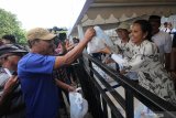 Menteri BUMN Rini Soemarno (kanan) membagikan paket sembako murah di Surabaya, Jawa Timur, Senin (3/6/2019). Program pangan murah yang diselenggarakan oleh PT Pelabuhan Indonesia III (Persero) itu menyediakan 3.000 paket sembako murah yang dijual dengan harga Rp10.000 kepada warga yang kurang mampu. Antara Jatim/Didik Suhartono/zk.