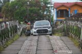 Pengendara melintas di jembatan yang berbahan kayu ulin di Kuin Banjarmasin,Kalimantan Selatan, Jumat (7/6/2019).Kondisi jembatan berbahan kayu ulin yang menghubungkan Kuin Utara dan Kuin Selatan tersebut sangat memprihatinkan.Foto Antaranews Kalsel/Bayu Pratama S.