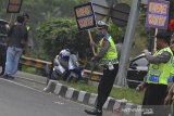 Polisi menunjukkan papan bertuliskan 'one way' atau sistem satu arah pada arus balik H+2 Lebaran di Jalur Selatan Lingkar Gentong, Kabupaten Tasikmalaya, Jawa Barat, Jumat (7/6/2019). Satlantas Polres Tasikmalaya Kota memberlakukan sistem satu arah untuk kendaraan pemudik dari arah Jawa Tengah menuju Bandung dan Jakarta untuk mengurai kepadatan kendaraan agar tidak terjadi kemacetan. ANTARA JABAR/Adeng Bustomi/agr