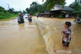 Sejumlah pengendara melintasi jalan poros pulau laut yang terendam banjir di Desa Sungup Kanan, Kabupaten Kotabaru, Kalimantan Selatan,Sabtu (8/6/2019).Hujan deras yang mengguyur Kabupaten Kotabaru selama tiga hari terakhir membuat air sungai meluap dan mengakibatkan akses jalan utama untuk menuju Kotabaru terendam banjir.Foto Antaranews Kalsel/Bayu Pratama S.