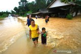 Sejumlah warga menorobos banjir di Desa Sungup Kanan, Kabupaten Kotabaru, Kalimantan Selatan,Sabtu (8/6/2019).Hujan deras yang mengguyur Kabupaten Kotabaru selama tiga hari terakhir membuat air sungai meluap dan mengakibatkan akses jalan utama untuk menuju Kotabaru terendam banjir.Foto Antaranews Kalsel/Bayu Pratama S.