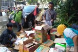 Relawan GMSS SKM Samarinda sedang mengeluarkan bantuan dari dus untuk dikemas per paket