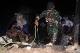 Anggota TNI melakukan pembasahan usai terjadi kebakaran di Pasar Waru, Pamekasan, Jawa Timur, Senin (10/6/2019). Warga dibantu TNI-Polri berhasil memadamkan api yang sempat menghanguskan sebagian bangunan pasar terbesar di daerah itu. Antara Jatim/Saiful Bahri/zk