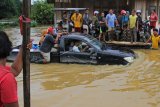 Sebuah mobil berusaha melintasi banjir luapan Sungai Pohara di Desa Andadowi, Konawe, Sulawesi Tenggara, Selasa (11/6/2019). Sungai Pohara meluap pada Senin (10/6/2019) sekitar pukul 11.30 WITA, akibat banjir bandang kiriman dari Sungai Konaweha dan menyebabkan akses jalan Trans Sulawesi yang menghubungan Sulawesi Tenggara-Sulawesi Tengah terhambat sementara antrean kendaran sepeda motor dan mobil mencapai 5 kilometer. ANTARA FOTO/Jojon/foc.