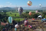 Warga menerbangkan balon udara saat mengikuti Festival Balon Ponorogo 2019 di Desa Nongkodono, Ponorogo, Jawa Timur, Rabu (12/6/2019). Festival balon yang digelar Kementerian Perhubungan bekerja sama dengan AirNav Indonesia, kepolisian dan pemerintah daerah setempat tersebut dilakukan untuk mensosialisasikan dan melestarikan tradisi balon udara yang aman dengan cara ditambatkan menggunakan tali untuk meminimalisir penerbangan balon udara secara liar yang dapat membahayakan keselamatan penerbangan. Antara Jatim/Fikri Yusuf/ZK