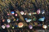 Warga menerbangkan balon udara saat mengikuti Festival Balon Ponorogo 2019 di Desa Nongkodono, Ponorogo, Jawa Timur, Rabu (12/6/2019). Festival balon yang digelar Kementerian Perhubungan bekerja sama dengan AirNav Indonesia, kepolisian dan pemerintah daerah setempat tersebut dilakukan untuk mensosialisasikan dan melestarikan tradisi balon udara yang aman dengan cara ditambatkan menggunakan tali untuk meminimalisir penerbangan balon udara secara liar yang dapat membahayakan keselamatan penerbangan. Antara Jatim/Fikri Yusuf/ZK