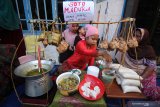 Seorang bocah melayani warga yang ingin menikmati hidangan ketupat gratis di Kampung Sukolilo, Kenjeran, Surabaya, Jawa Timur, Rabu (12/6/2019). Tradisi Lebaran Ketupat yang dirayakan pada hari ketujuh setelah Hari Raya Idul Fitri di kampung tersebut dimeriahkan dengan membagikan hidangan ketupat secara gratis kepada warga lainnya sebagai ungkapan rasa syukur dan mempererat persaudaraan. Antara Jatim/Moch Asim/zk.