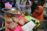 Dua bocah menyiapkan hidangan ketupat gratis di Kampung Sukolilo, Kenjeran, Surabaya, Jawa Timur, Rabu (12/6/2019). Tradisi Lebaran Ketupat yang dirayakan pada hari ketujuh setelah Hari Raya Idul Fitri di kampung tersebut dimeriahkan dengan membagikan hidangan ketupat secara gratis kepada warga lainnya sebagai ungkapan rasa syukur dan mempererat persaudaraan. Antara Jatim/Moch Asim/zk.