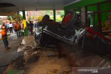 Warga menyaksikan mobil pikap yang terguling setelah ditabrak bus hingga menghantam rumah makan di Bandar Kedungmulyo, Jombang, Jawa Timur, Rabu (12/6/2019).  Kecelakaan yang menewaskan 3 orang salah satunya anggota TNI AL tersebut diduga disebabkan bus Harapan Jaya nopol AG 7391 US ugal-ugalan kemudian menabrak pikap nopol AE 8832 YA hingga menabrak rumah makan. Antara Jatim/Syaiful Arif/zk.