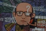 Seorang pejalan kaki melintas di depan mural berisi kritik sosial di Desa Linggasari, Kabupaten Ciamis, Jawa Barat, Kamis (13/6/2019). Mural kritik sosial tersebut merupakan bentuk media penyampaian kritik sosial dan ajakan kepada masyarakat untuk lebih peka serta peduli terhadap pengungkapan kasus penyerangan terhadap penyidik Komisi Pemberantasan Korupsi (KPK) Novel Baswedan. ANTARA JABAR/Adeng Bustomi/agr