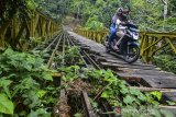 Pengendara motor melintasi Jembatan Bailey Gobang yang rusak di Kampung Gobang, Kota Tasikmalaya, Jawa Barat, Jumat (14/6/2019). Jembatan Bailey Gobang yang menghubungkan Kota Tasikmalaya dengan Kabupaten Tasikmalaya serta Kabupaten Ciamis tersebut rusak dan tidak layak dilintasi kendaraan, sehingga membahayakan warga yang melintas. ANTARA JABAR/Adeng Bustomi/agr