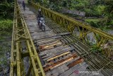 Pengendara motor melintasi Jembatan Bailey Gobang yang rusak di Kampung Gobang, Kota Tasikmalaya, Jawa Barat, Jumat (14/6/2019). Jembatan Bailey Gobang yang menghubungkan Kota Tasikmalaya dengan Kabupaten Tasikmalaya serta Kabupaten Ciamis tersebut rusak dan tidak layak dilintasi kendaraan, sehingga membahayakan warga yang melintas. ANTARA JABAR/Adeng Bustomi/agr