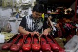 Pengrajin membuat sepatu kulit sapi untuk selanjutnya dikirim ke Jakarta, Bandung dan Banyuwangi di sebuah industri sepatu rumahan di Polehan, Malang, Jawa Timur, Jumat (14/6/2019). Pengusaha sepatu kulit setempat mengaku bahwa penjualan melalui pasar daring membuat permintaannya meningkat hingga lima kali lipat dan konsumennya sebagian besar adalah kaum wanita. Antara Jatim/Ari Bowo Sucipto/ZK