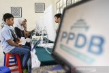 Orangtua dan calon siswa berbincang dengan petugas saat sosialisasi dan simulasi pendaftaran Penerimaan Peserta Didik Baru (PPDB) 2019 tingkat SMA-SMK di Bandung, Jawa Barat, Jumat (14/6/2019). Sosialisasi dan simulasi tersebut guna memahami jenis jalur penerimaan peserta didik baru dan memilih jalur yang sesuai dengan jarak rumah ke sekolah, nilai UN, prestasi UN dan non-UN serta pertimbangan lainnya. ANTARA JABAR/M Agung Rajasa/agr