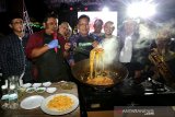 Wali Kota Banda Aceh Aminullah Usman (tengah) memasak mie Aceh pada pembukaan festival mie Aceh 2019 di Blangpadang, Banda Aceh, Aceh, Sabtu (15/06/2019). Festival mie yang brelangsung selama tiga hari bertujuan mempromosikan kota Banda Aceh sebagai destinasi wisata kuliner halal, budaya dan religi di Indonesia. (Antara Aceh/Irwansyah Putra)