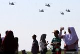 Warga menyaksikan formasi terbang Heli Bell-412 milik Skuadron Udara 400 saat upacara peringatan Hari Penerbangan Angkatan Laut di Apron Hanggar Lanudal Juanda Surabaya di Sidoarjo, Jawa Timur, Senin (17/6/2019). HUT Penerbangan TNI AL ke-63 Tahun tersebut mengambil tema 